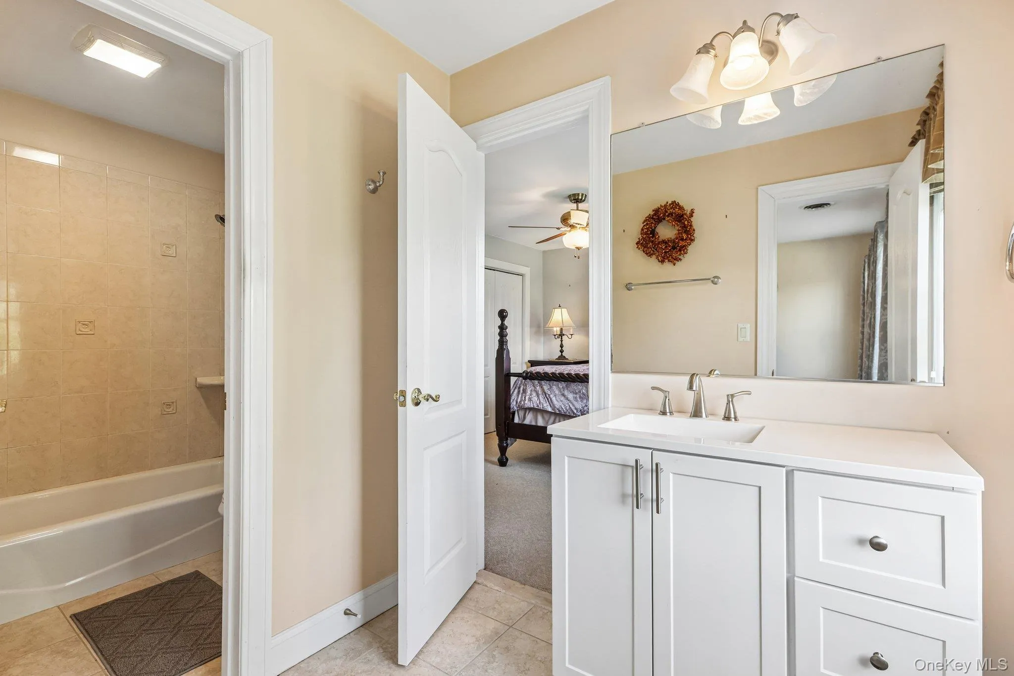 Bathroom vanity with a white countertop, undermount sink, and brushed nickel faucet Bathroom vanity with a white countertop, undermount sink, and brushed nickel faucet