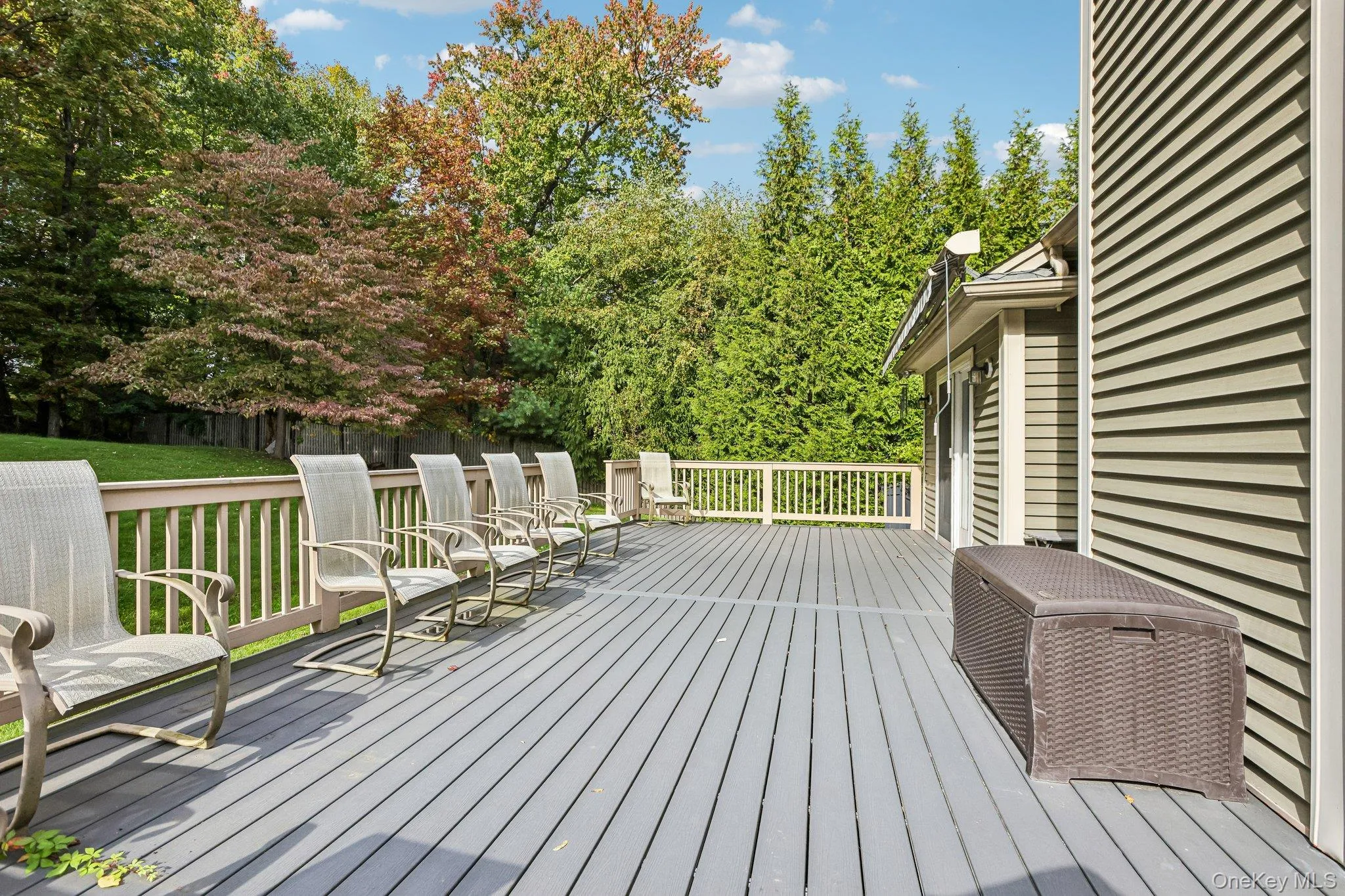 Expansive gray composite deck featuring a light-toned railing and exterior siding Expansive gray composite deck featuring a light-toned railing and exterior siding