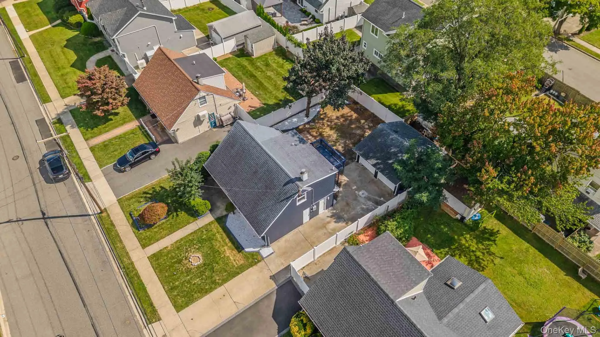 Aerial perspective showcasing a residential street, multiple properties with pitched roofs, and established trees Aerial perspective showcasing a residential street, multiple properties with pitched roofs, and established trees