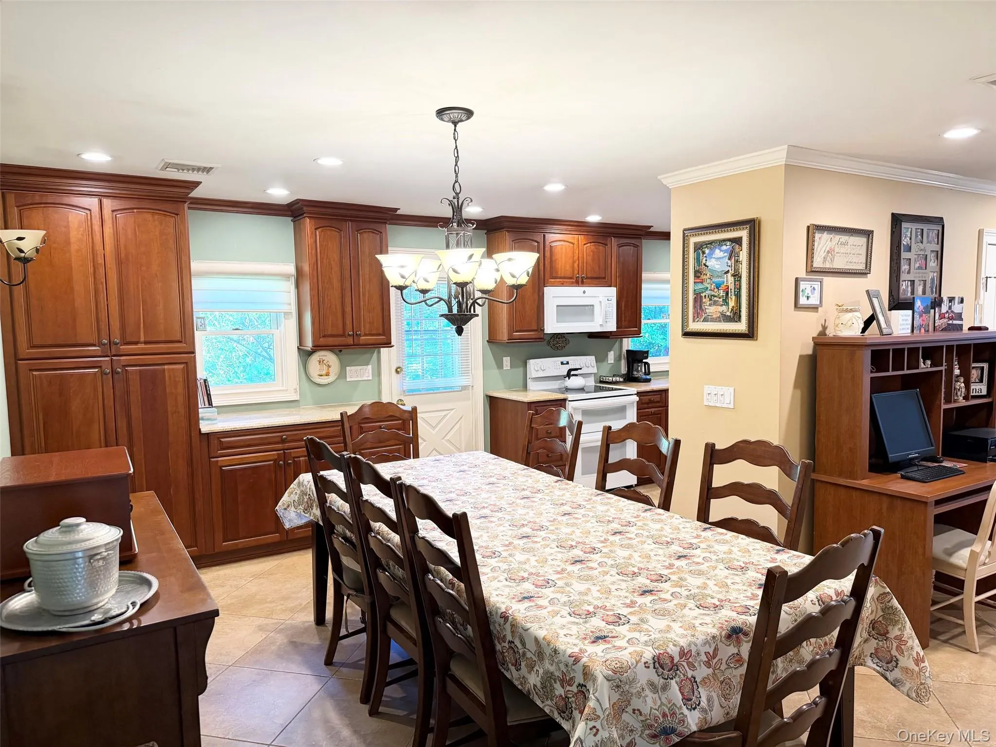 Kitchen featuring wood cabinetry, white appliances, recessed lighting, and a built-in desk area Kitchen featuring wood cabinetry, white appliances, recessed lighting, and a built-in desk area