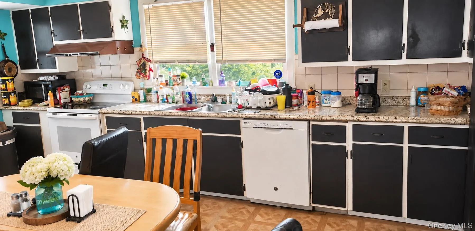 Kitchen with black and white cabinetry, granite-finish countertops, and a double basin sink Kitchen with black and white cabinetry, granite-finish countertops, and a double basin sink