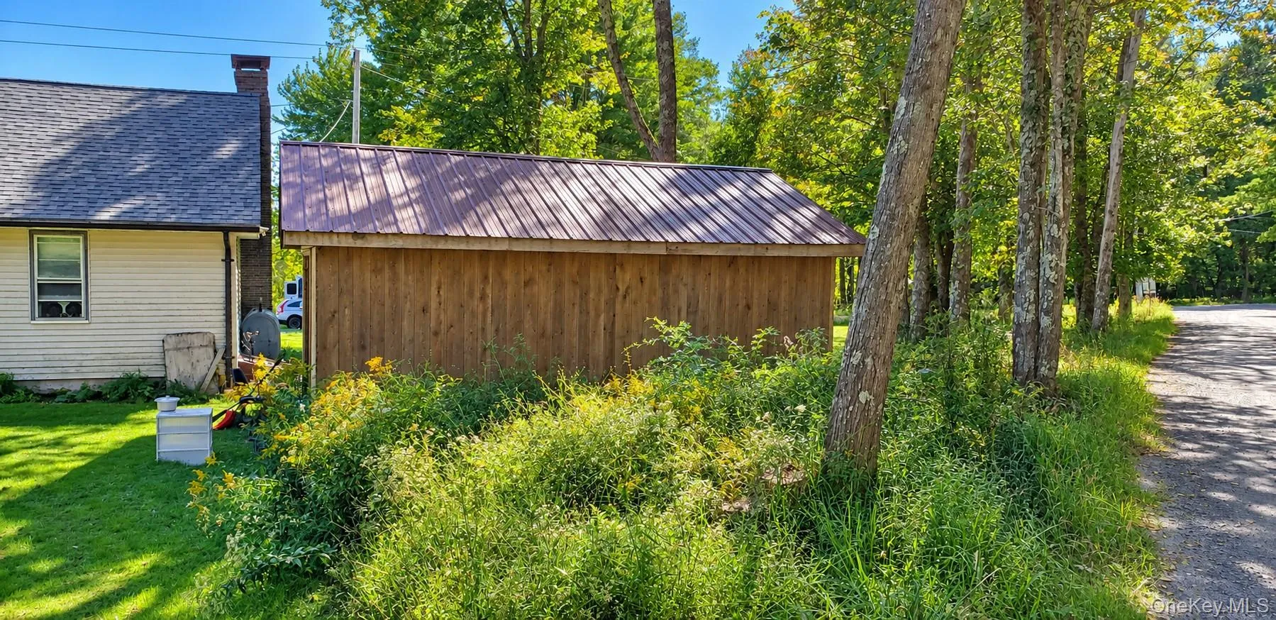 Wood-sided outbuilding with a corrugated metal roof Wood-sided outbuilding with a corrugated metal roof