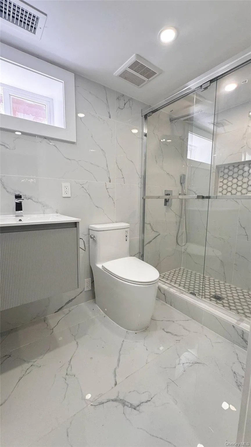 Contemporary bathroom featuring a floating vanity, frameless glass shower enclosure, and full-height tile surround Contemporary bathroom featuring a floating vanity, frameless glass shower enclosure, and full-height tile surround