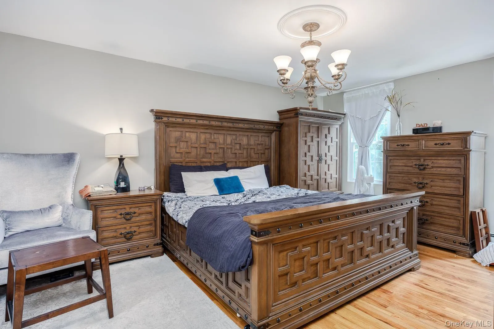 Hardwood flooring, ceiling medallion, chandelier, and a window with white drapes Hardwood flooring, ceiling medallion, chandelier, and a window with white drapes