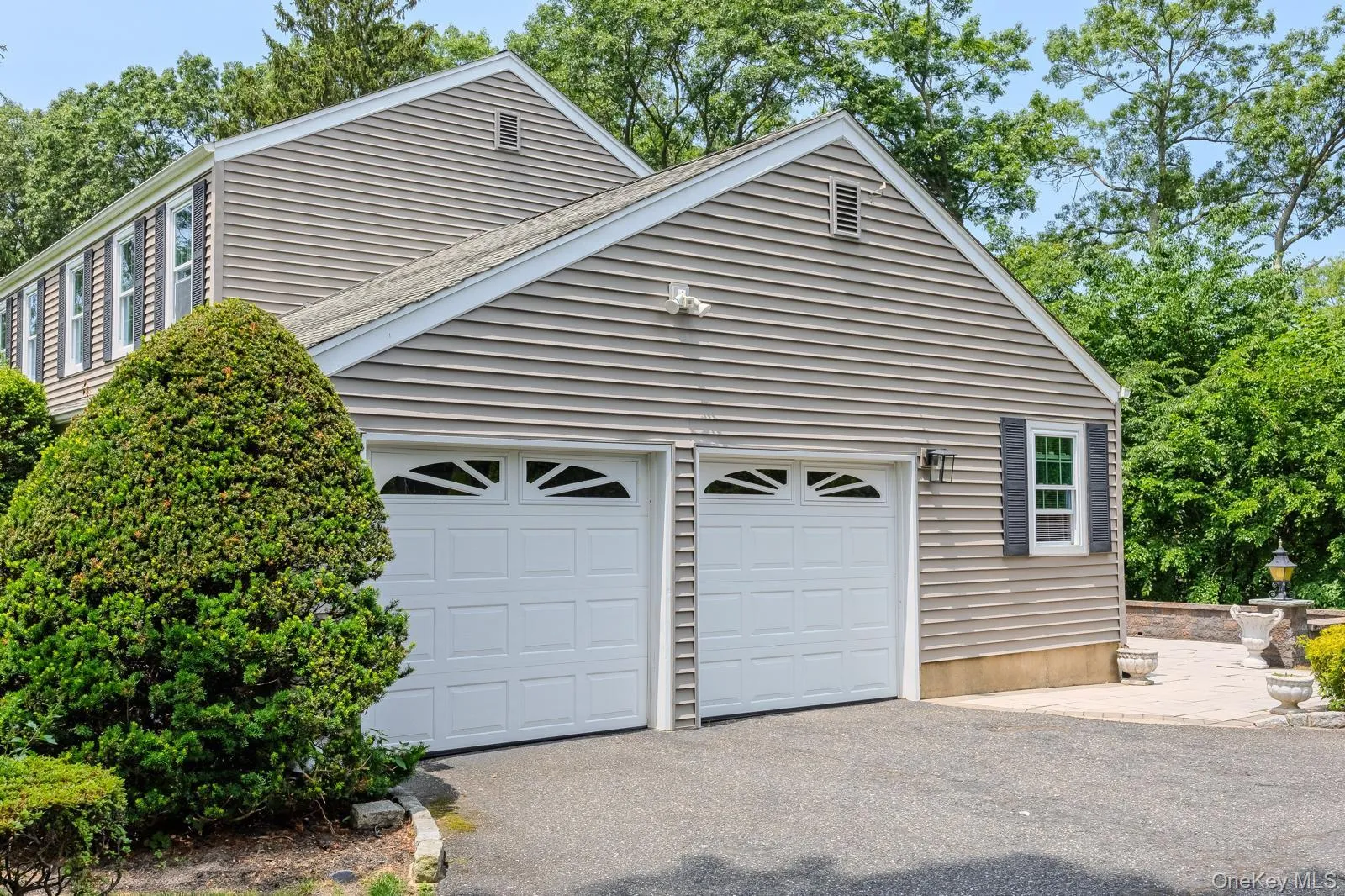 Two-car garage with white paneled automation doors Two-car garage with white paneled automation doors