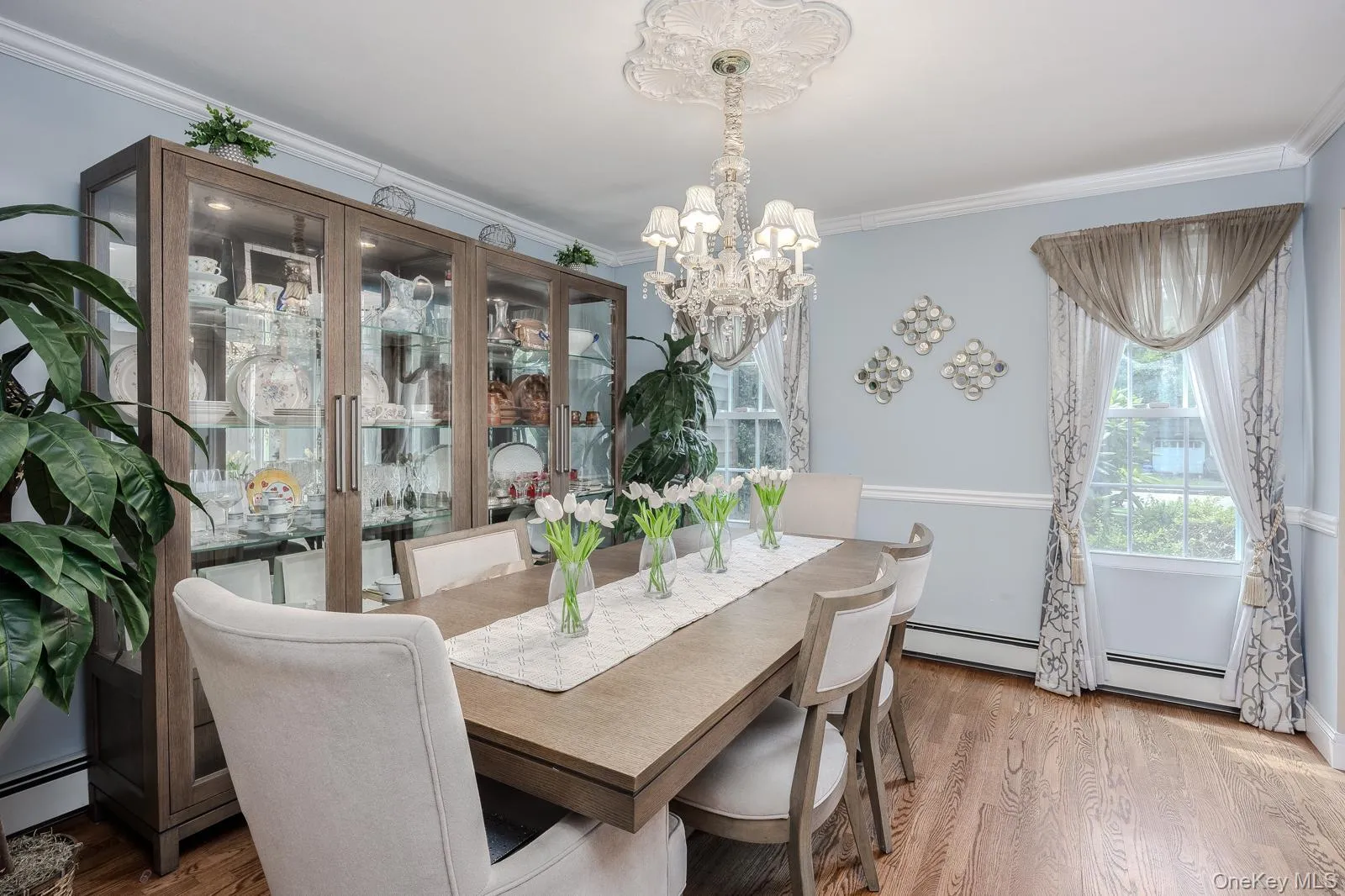 Formal Dining Room with hardwood flooring throughout, featuring crown molding, a decorative ceiling medallion, and an elaborate chandelier Formal Dining Room with hardwood flooring throughout, featuring crown molding, a decorative ceiling medallion, and an elaborate chandelier