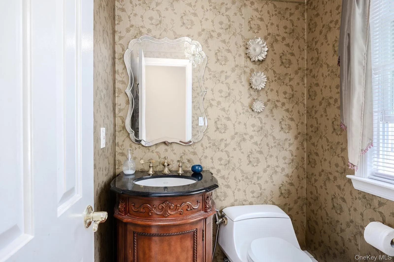 Half Bathroom ornate vanity with dark countertop, undermount sink, and decorative faucet Half Bathroom ornate vanity with dark countertop, undermount sink, and decorative faucet