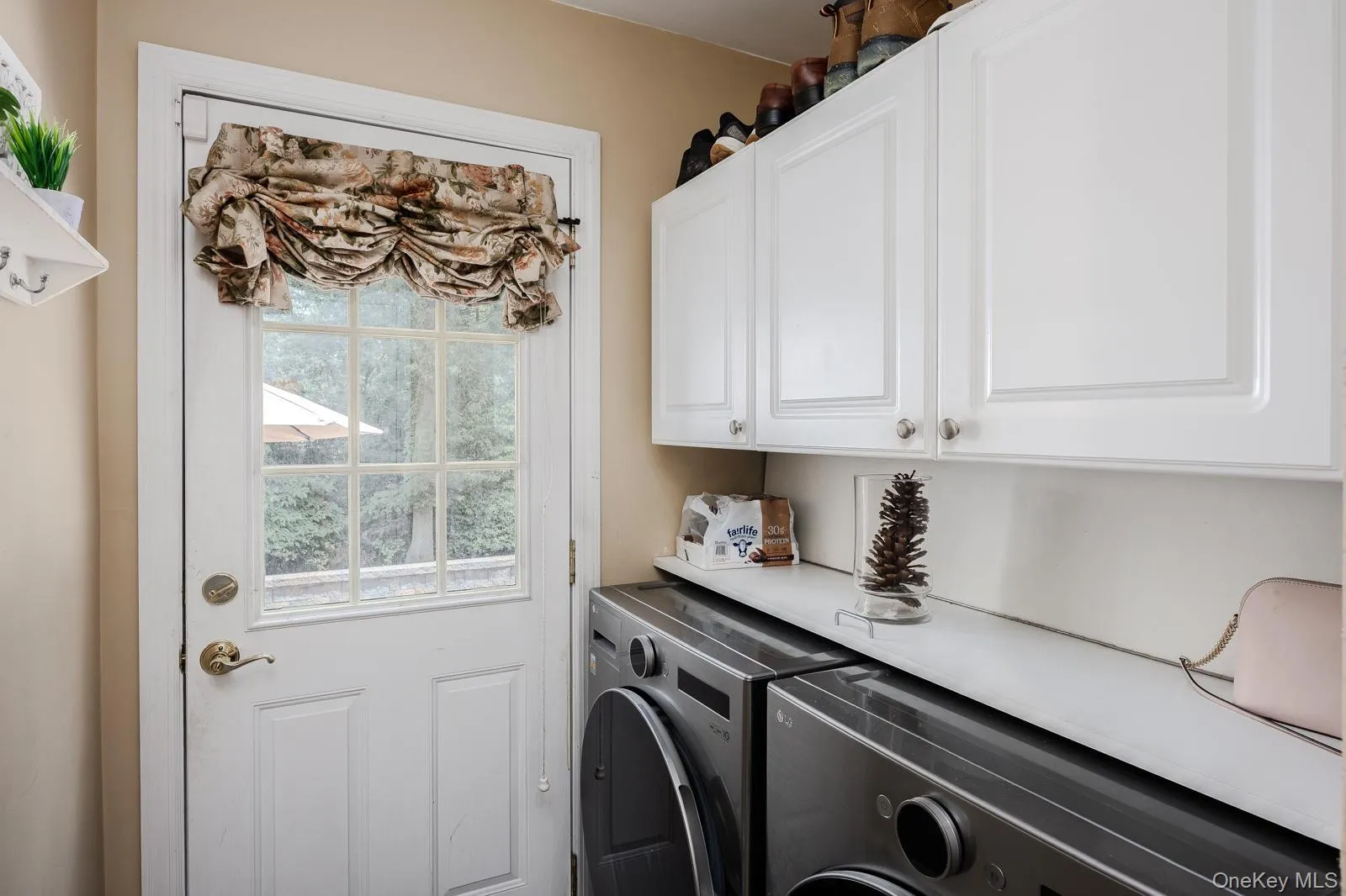 laundry room with white paneled door with window, overhead white cabinetry, and built-in countertop laundry room with white paneled door with window, overhead white cabinetry, and built-in countertop