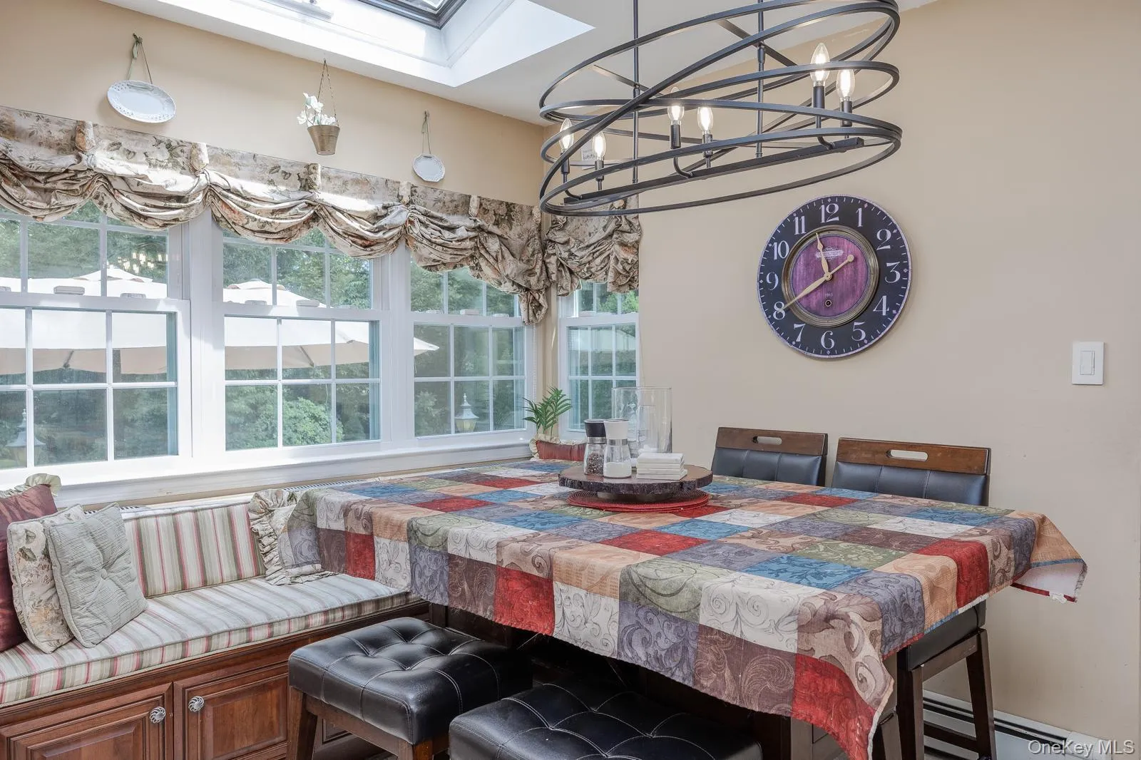 Built-in window seating with storage, multiple windows, skylight, and an overhead multi-light fixture Built-in window seating with storage, multiple windows, skylight, and an overhead multi-light fixture