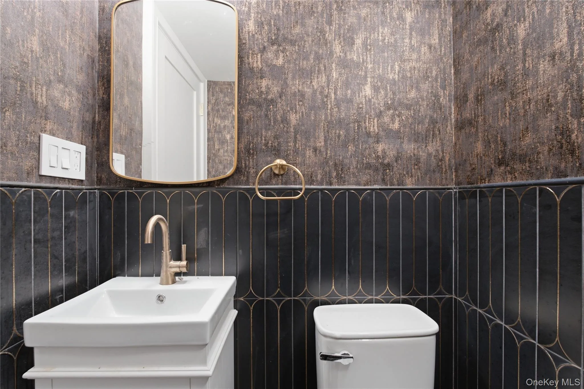Stylishly Updated Half BathroomThis beautifully updated half bathroom features a sophisticated contemporary design with striking tilework, a sleek vanity, modern fixtures, and an elegant mirror. Thoughtfully designed with both style and functionality in mind, this chic powder room adds a polished finishing touch to the home. Stylishly Updated Half BathroomThis beautifully updated half bathroom features a sophisticated contemporary design with striking tilework, a sleek vanity, modern fixtures, and an elegant mirror. Thoughtfully designed with both style and functionality in mind, this chic powder room adds a polished finishing touch to the home.