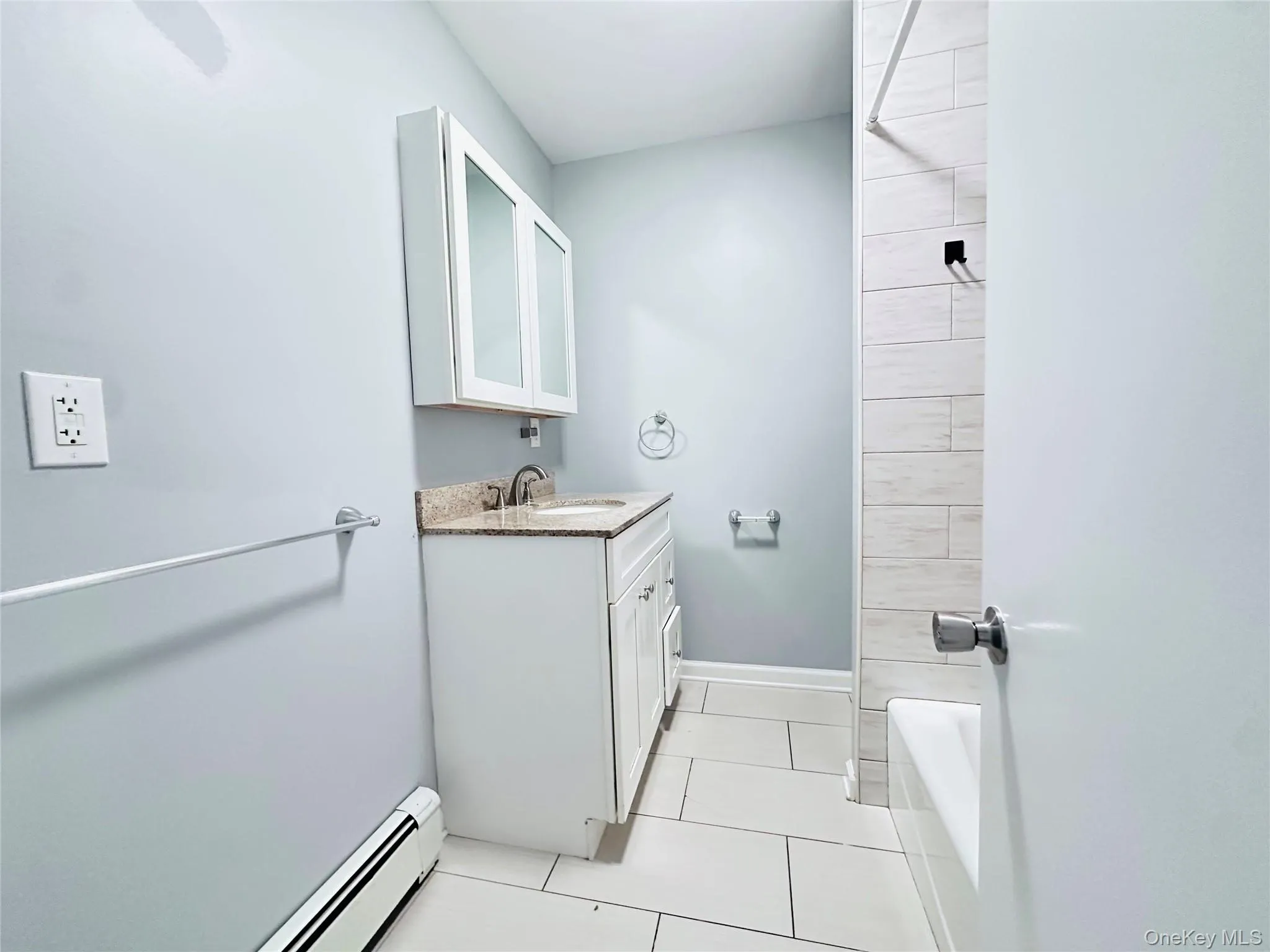 Renovated 4 fixture bathroom with quartz top vanity and light colored tiles. Renovated 4 fixture bathroom with quartz top vanity and light colored tiles.