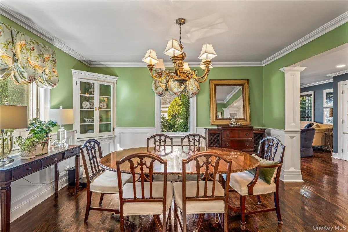 Hardwood flooring, decorative chandelier, corner built-in cabinet, wainscoting, and crown molding. Hardwood flooring, decorative chandelier, corner built-in cabinet, wainscoting, and crown molding.