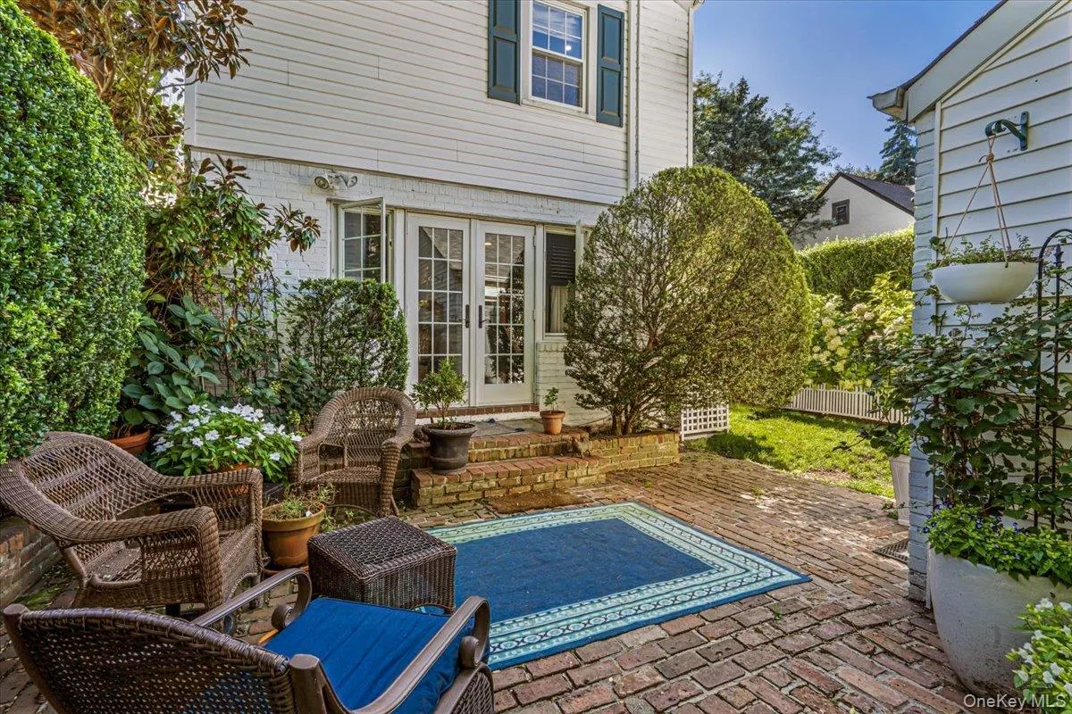 Brick paver patio with double French doors, and mature landscaping Brick paver patio with double French doors, and mature landscaping