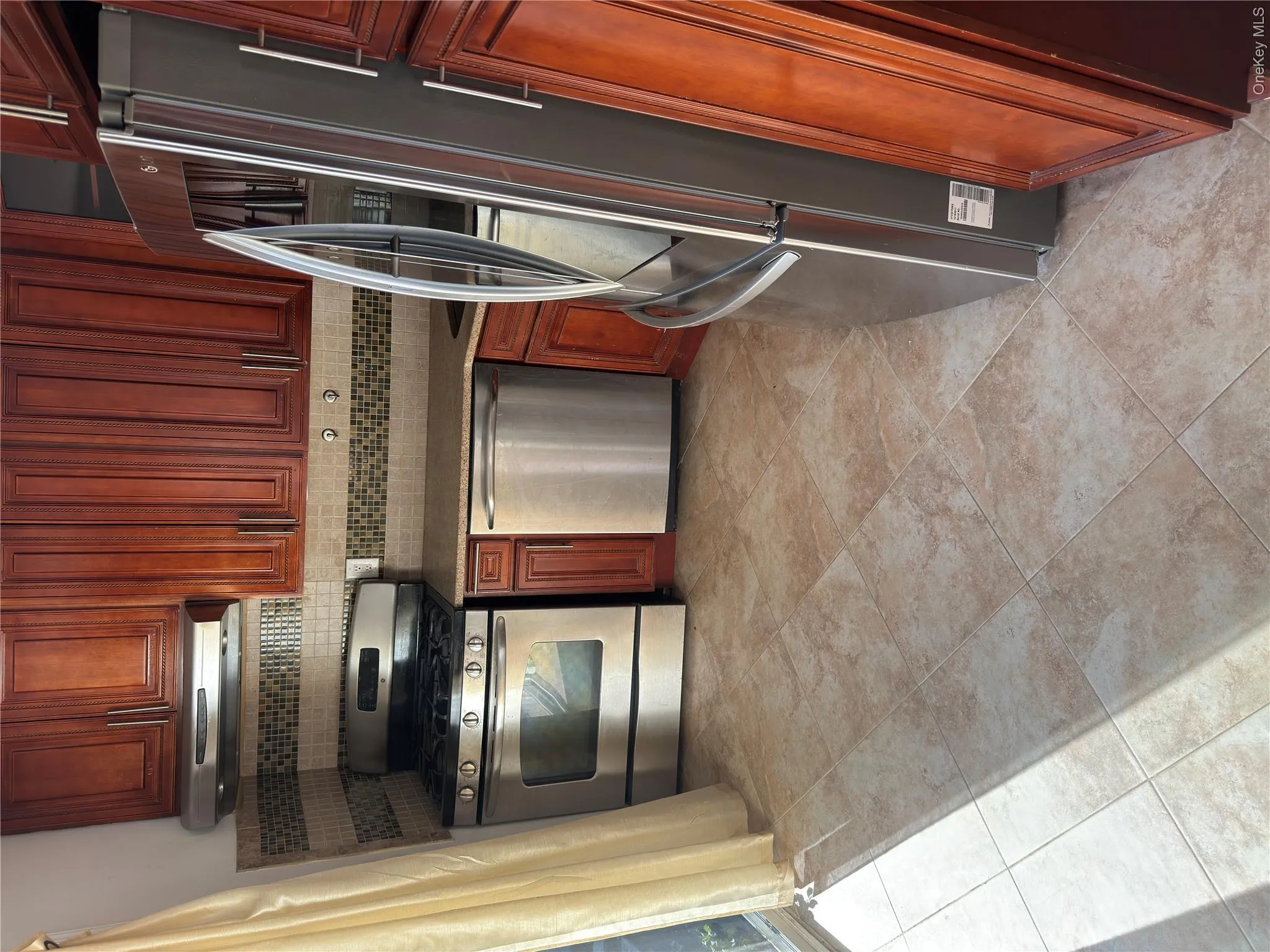Full suite of stainless steel appliances, rich wood-finish cabinetry, tile backsplash, and durable tile flooring Full suite of stainless steel appliances, rich wood-finish cabinetry, tile backsplash, and durable tile flooring