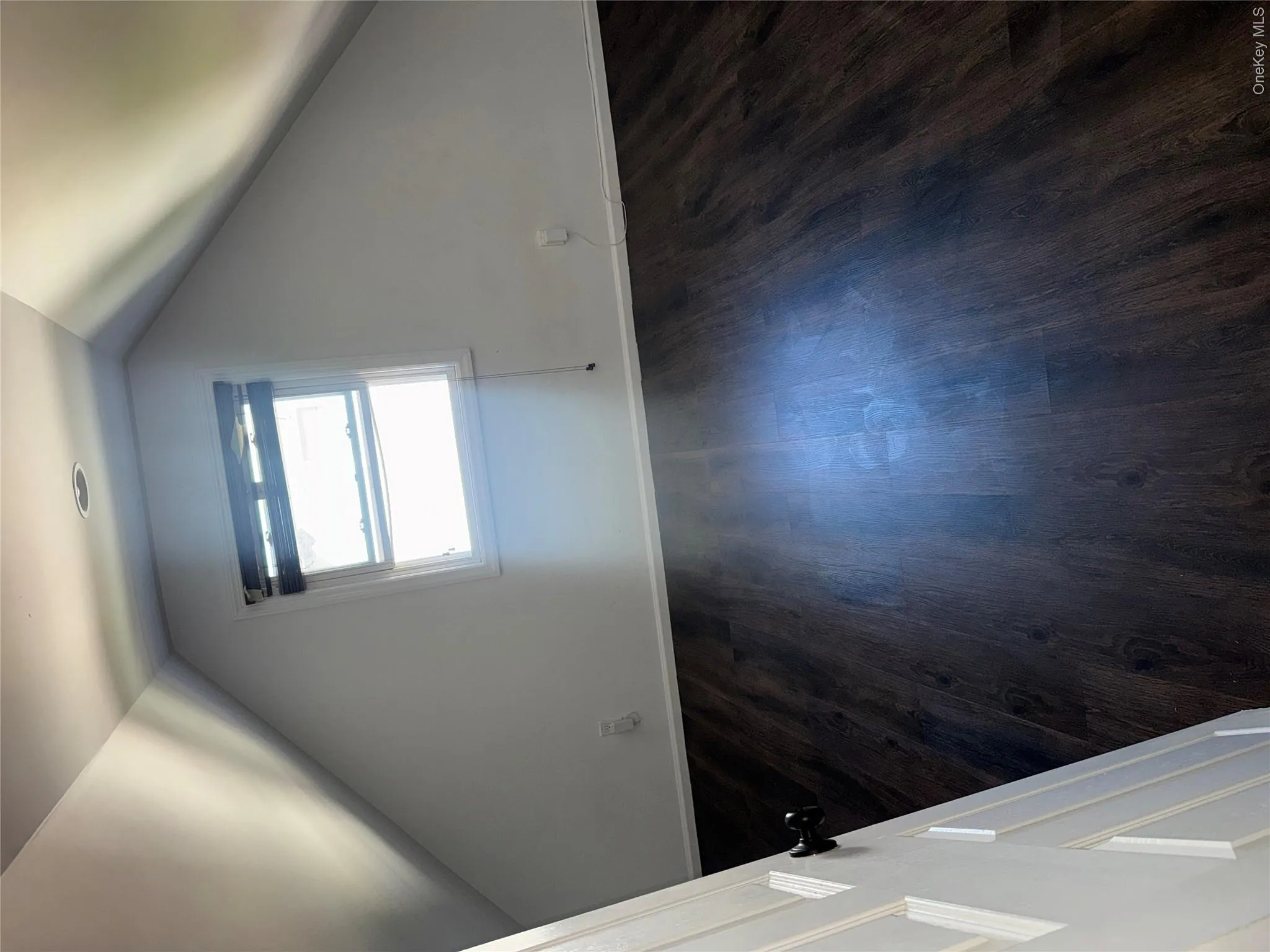 Attic space featuring wood-finish flooring, recessed lighting, and a window with blinds Attic space featuring wood-finish flooring, recessed lighting, and a window with blinds