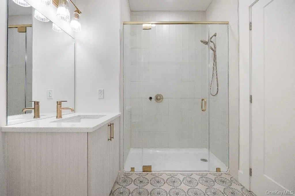 Bathroom featuring vanity and a shower with door Bathroom featuring vanity and a shower with door