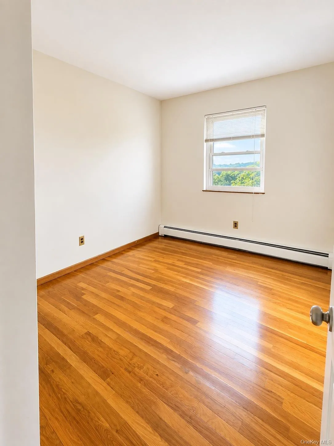 Hardwood flooring, neutral wall tones, and window with blinds Hardwood flooring, neutral wall tones, and window with blinds