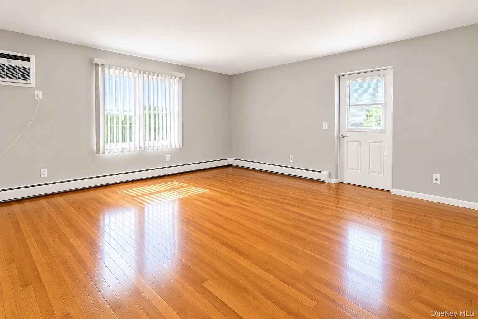 Hardwood flooring, light gray wall color, white trim, window with vertical blinds, and a white paneled door with glass insert Hardwood flooring, light gray wall color, white trim, window with vertical blinds, and a white paneled door with glass insert