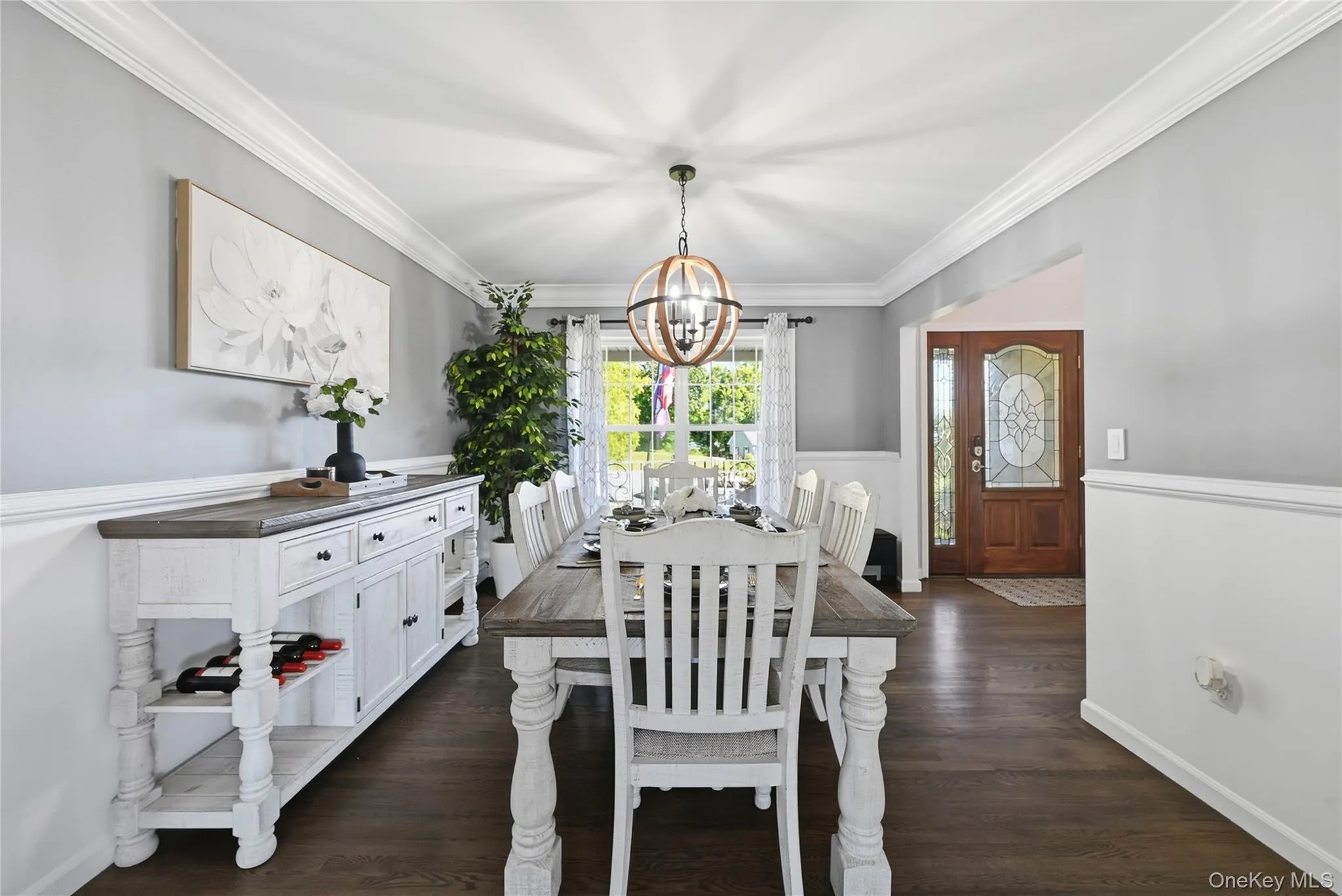 Hardwood-finish flooring, crown molding, chair rail detailing, recessed window, and a decorative front door with leaded glass accents Hardwood-finish flooring, crown molding, chair rail detailing, recessed window, and a decorative front door with leaded glass accents
