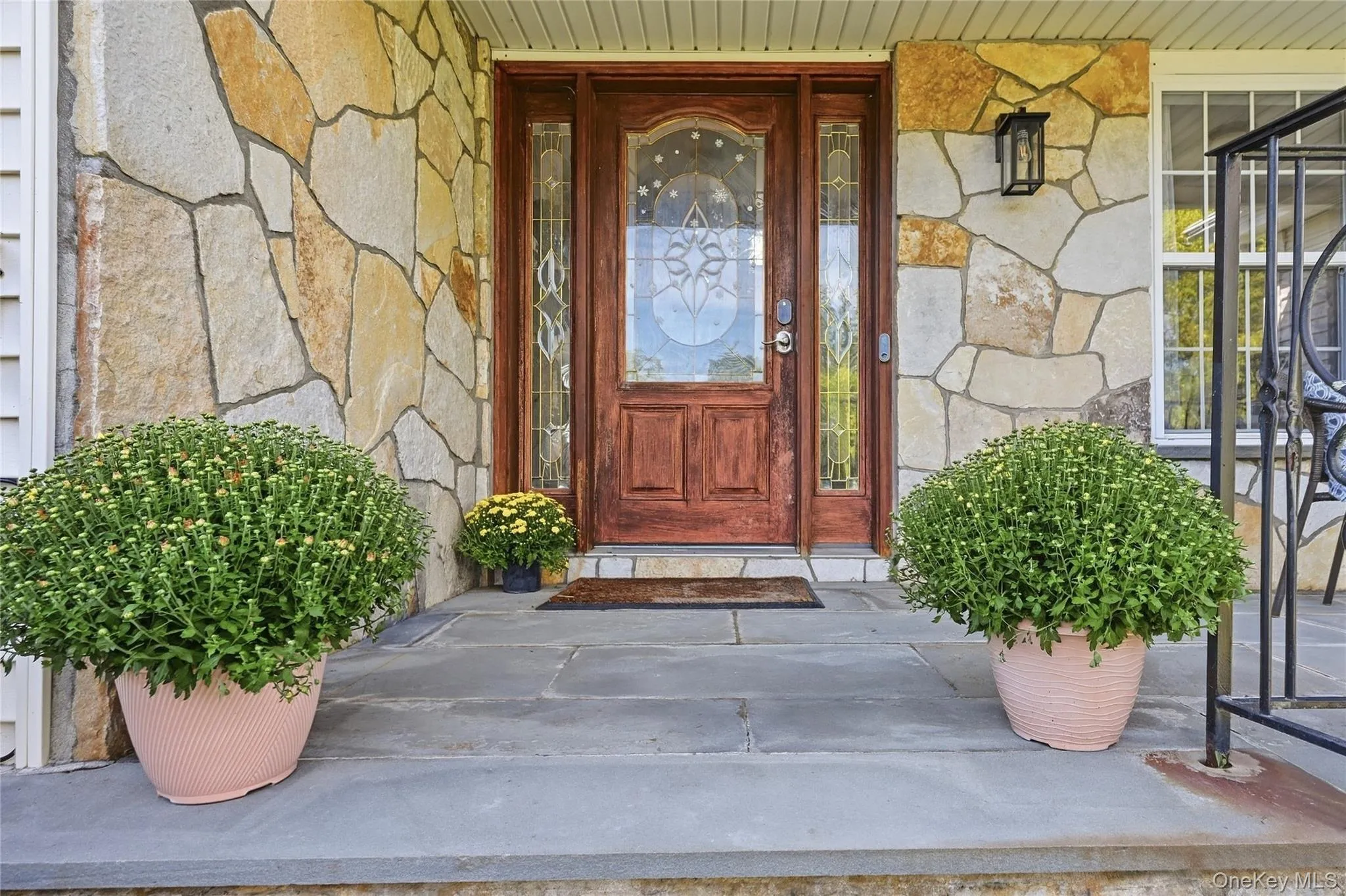 Natural stone facade, solid wood entry door, decorative glass sidelights, transom window, and stone entryway Natural stone facade, solid wood entry door, decorative glass sidelights, transom window, and stone entryway
