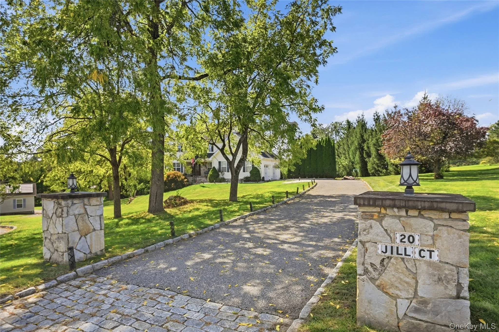 Cobblestone entry leading to a paved driveway Cobblestone entry leading to a paved driveway