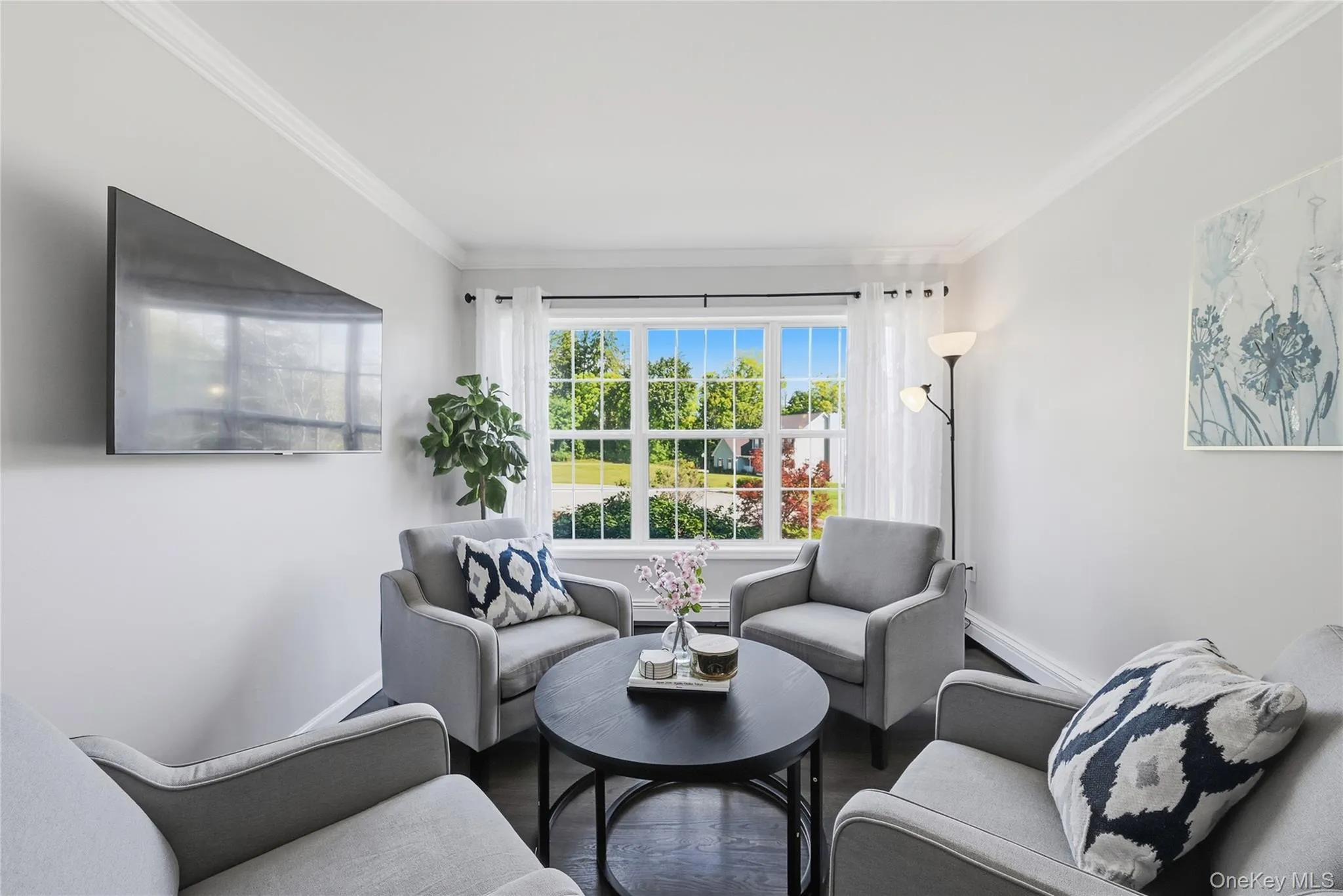 Crown molding, dark wood-finish flooring, white window trim, and a wall-mounted television Crown molding, dark wood-finish flooring, white window trim, and a wall-mounted television