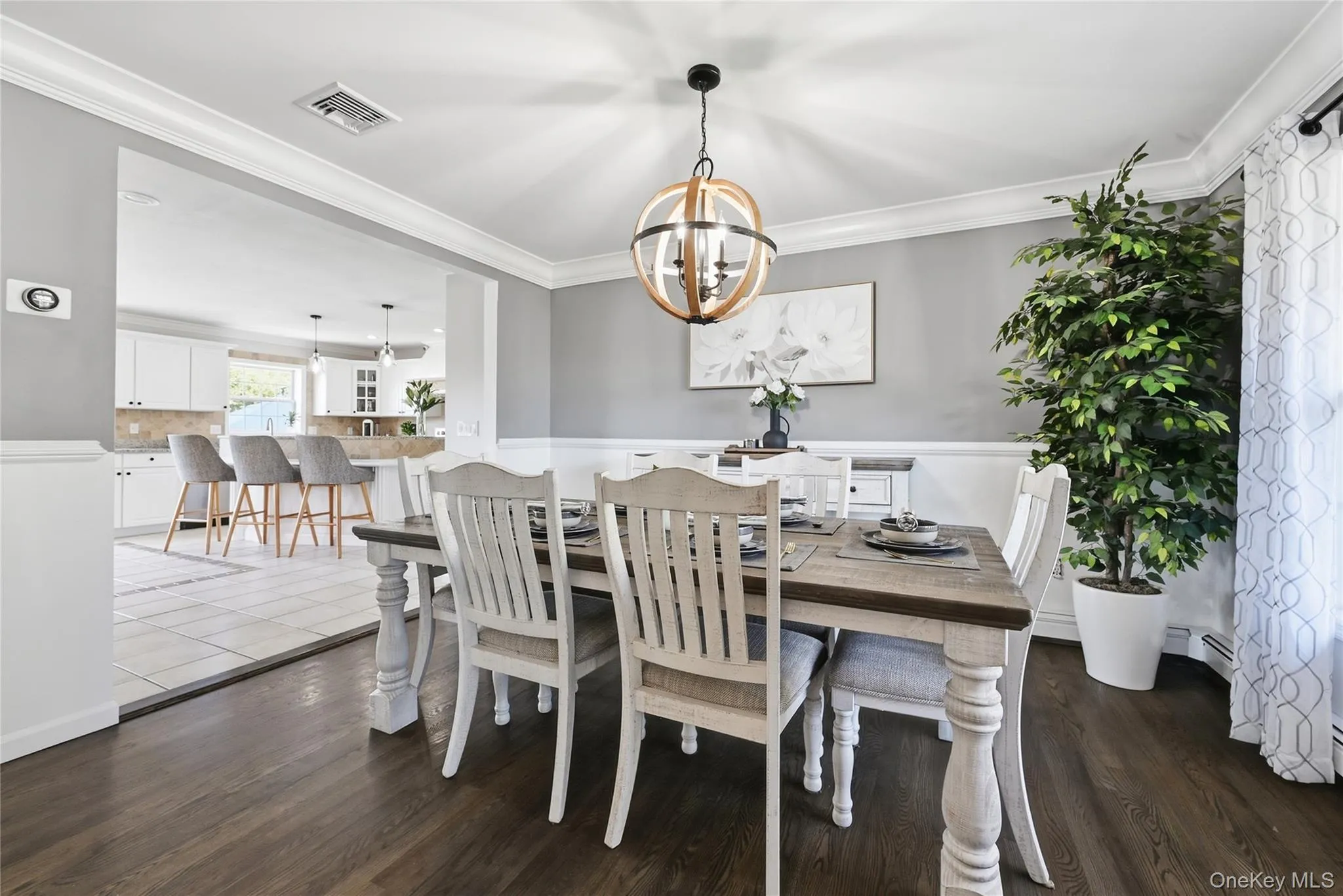 Wood-finish flooring, crown molding, chair rail, and an open concept layout Wood-finish flooring, crown molding, chair rail, and an open concept layout