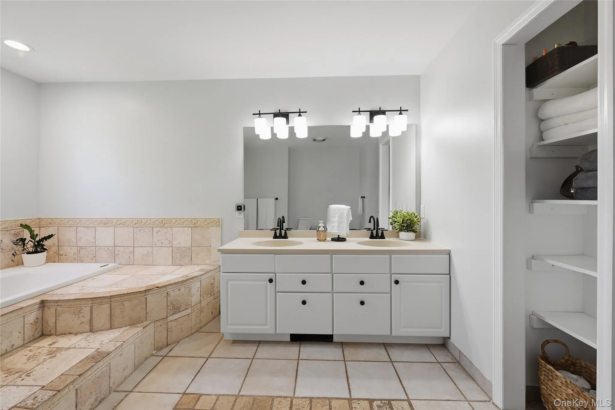 Dual vanity with individual sinks, white cabinetry, and black hardware Dual vanity with individual sinks, white cabinetry, and black hardware