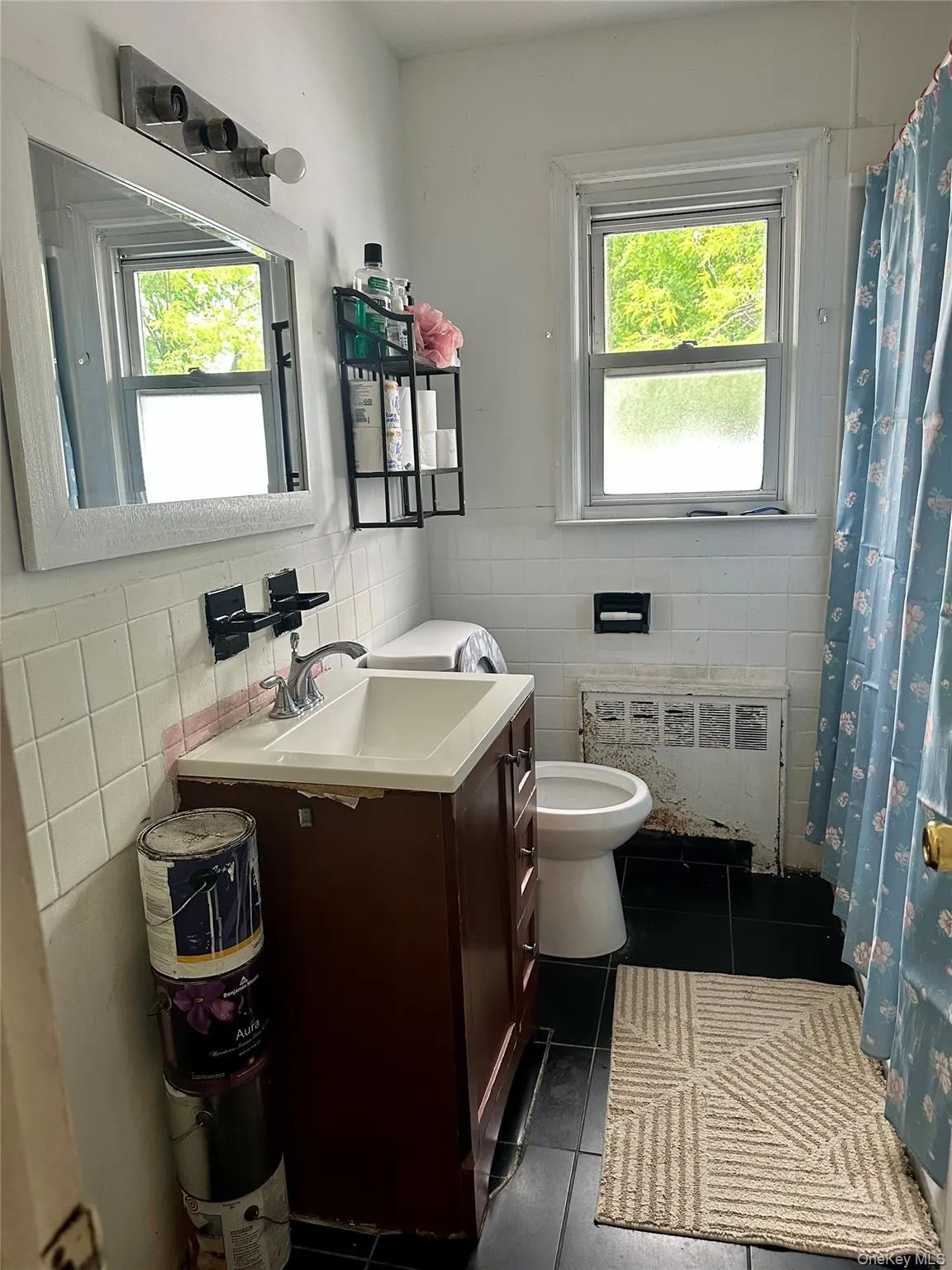 Bathroom with radiator, tile walls, toilet, and tile patterned flooring Bathroom with radiator, tile walls, toilet, and tile patterned flooring