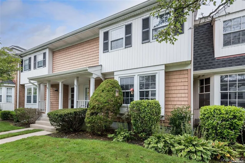Two-story exterior featuring white vertical siding, shingle siding accents, and a covered porch entry Two-story exterior featuring white vertical siding, shingle siding accents, and a covered porch entry