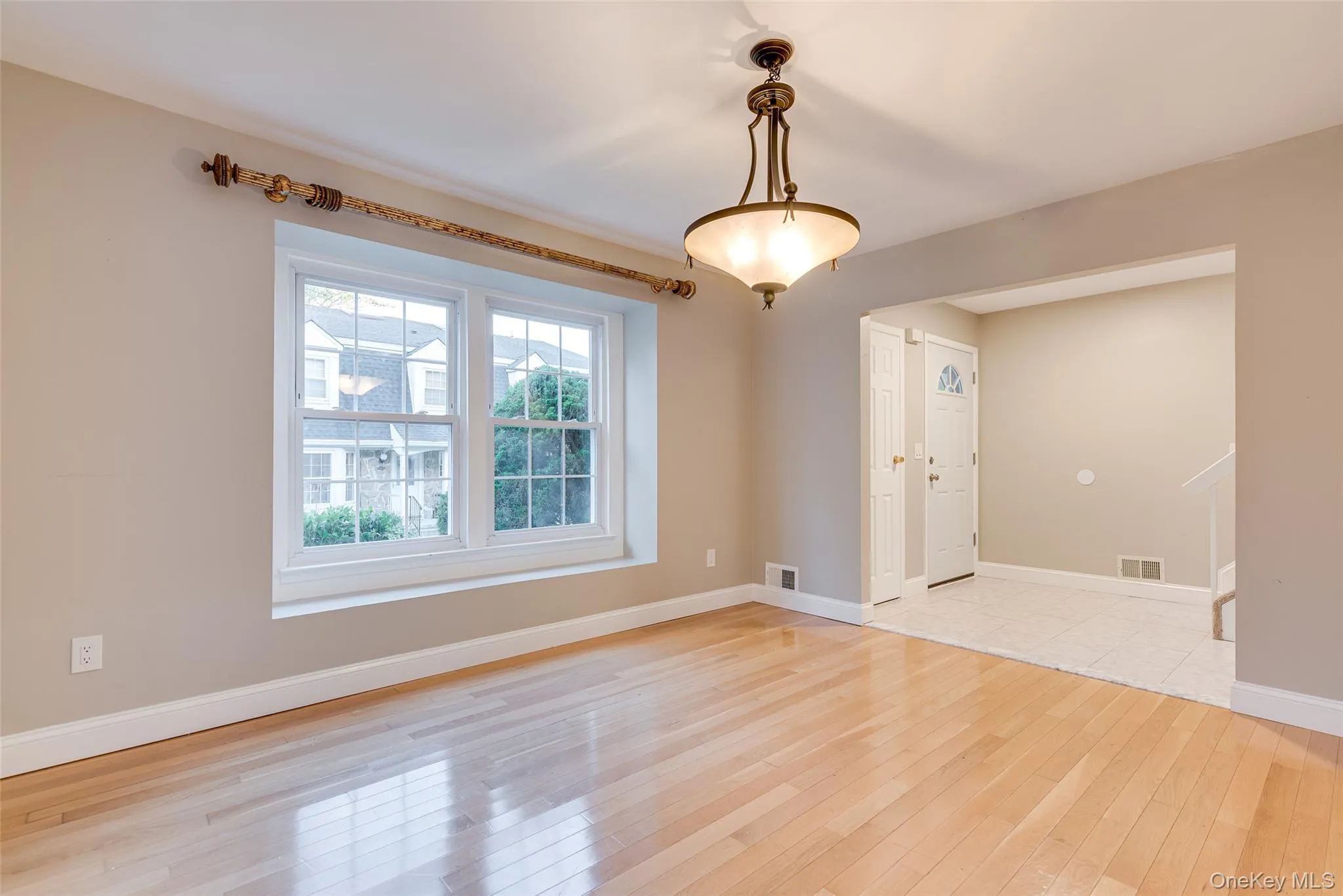 Hardwood flooring, recessed window, classic chandelier, arched entryway, and tile flooring Hardwood flooring, recessed window, classic chandelier, arched entryway, and tile flooring