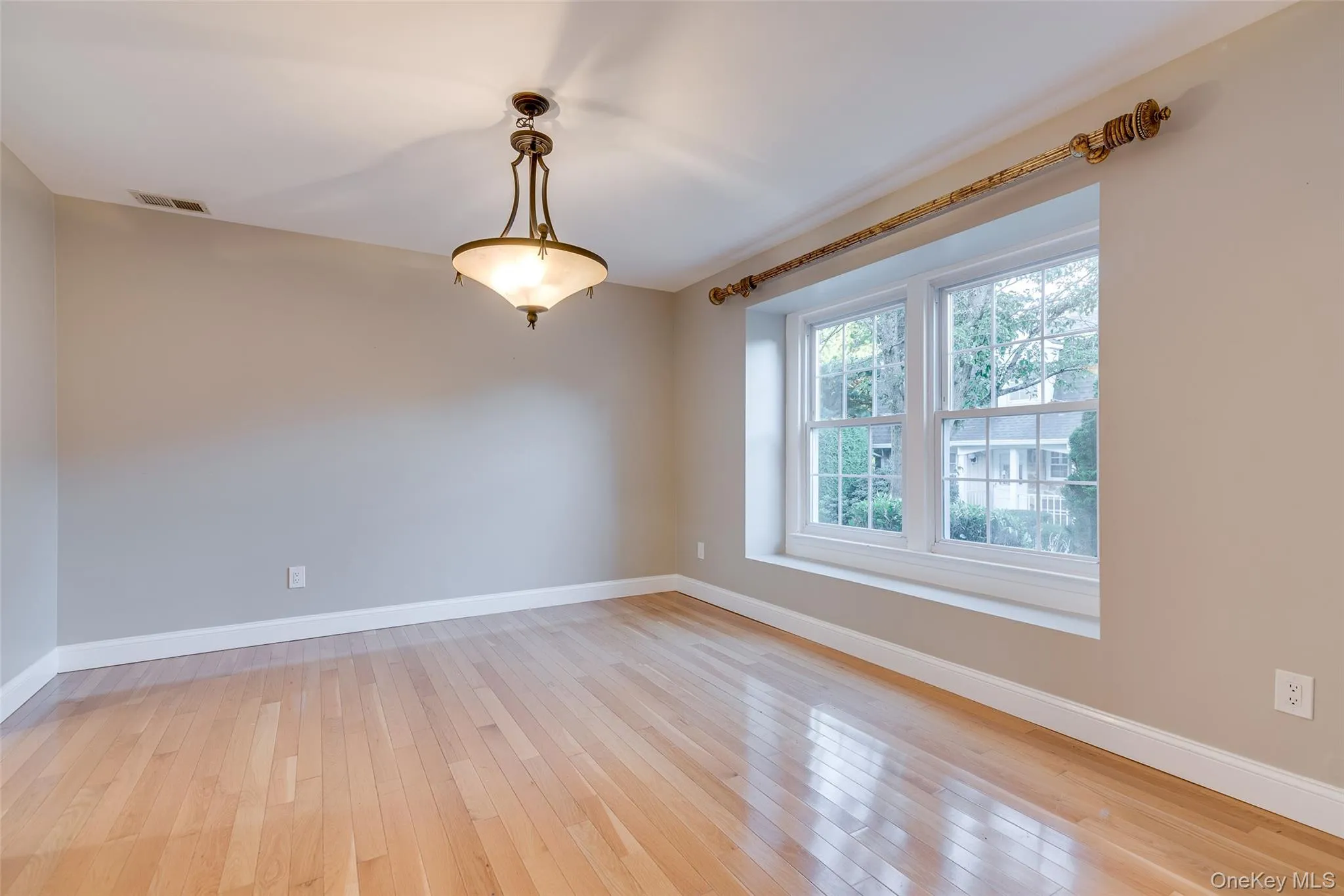 Hardwood flooring, painted walls, two double-hung windows, and a ceiling-mounted light fixture Hardwood flooring, painted walls, two double-hung windows, and a ceiling-mounted light fixture