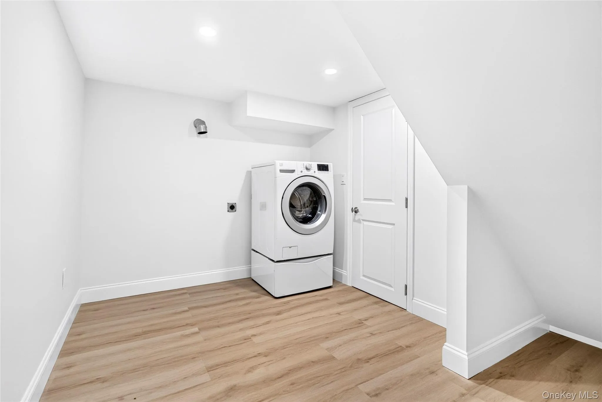 Recessed lighting, wood-finish flooring, white paneled door, and angled ceiling Recessed lighting, wood-finish flooring, white paneled door, and angled ceiling