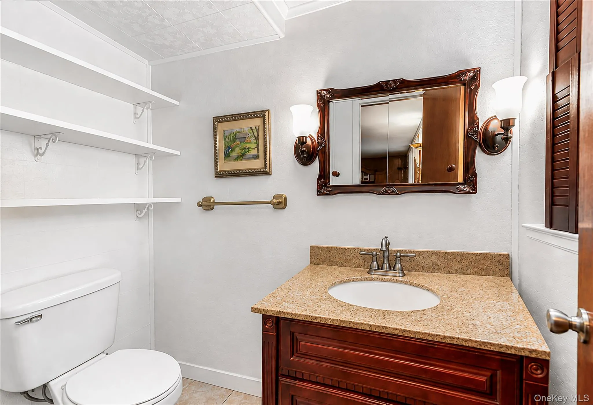 Corner vanity with a light-toned countertop and a decorative wood-framed mirror Corner vanity with a light-toned countertop and a decorative wood-framed mirror
