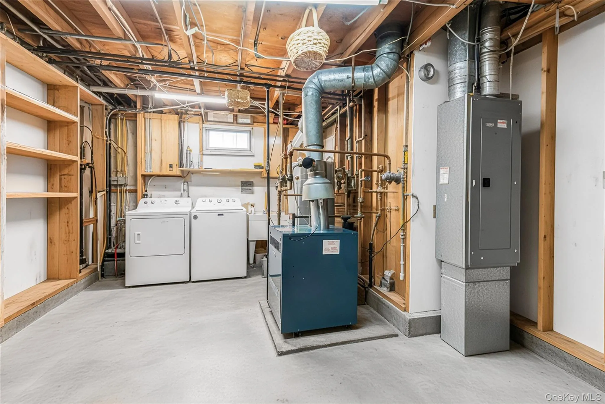 Laundry area with concrete flooring, exposed ceiling joists, and a utility sink Laundry area with concrete flooring, exposed ceiling joists, and a utility sink