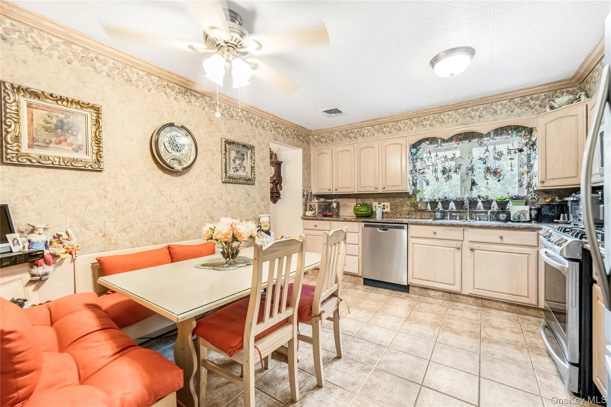 Kitchen featuring light-toned cabinetry, tile flooring, and stainless steel appliances Kitchen featuring light-toned cabinetry, tile flooring, and stainless steel appliances