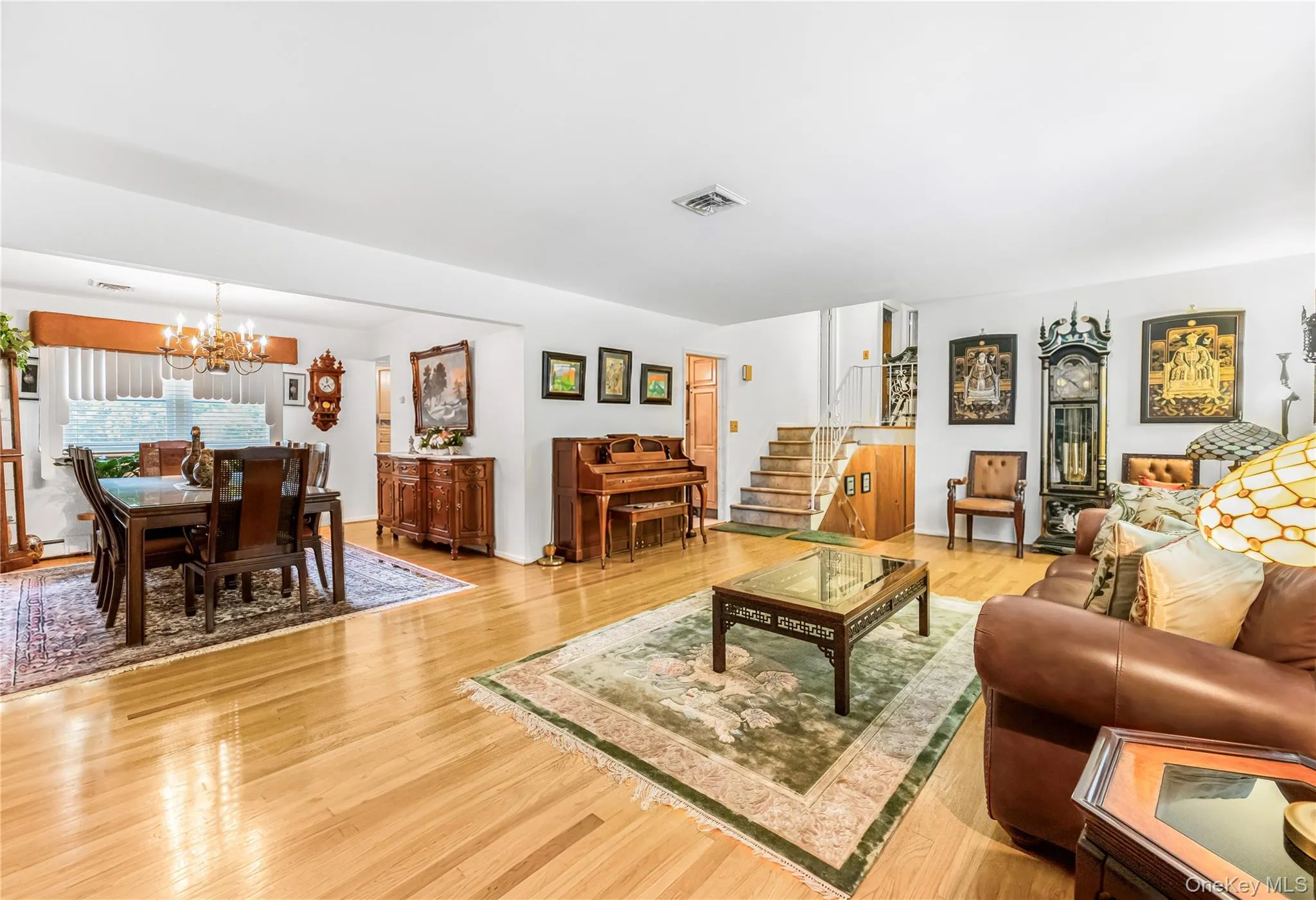Light wood-finish flooring, white walls, and a multi-level floor plan with visible stairs Light wood-finish flooring, white walls, and a multi-level floor plan with visible stairs