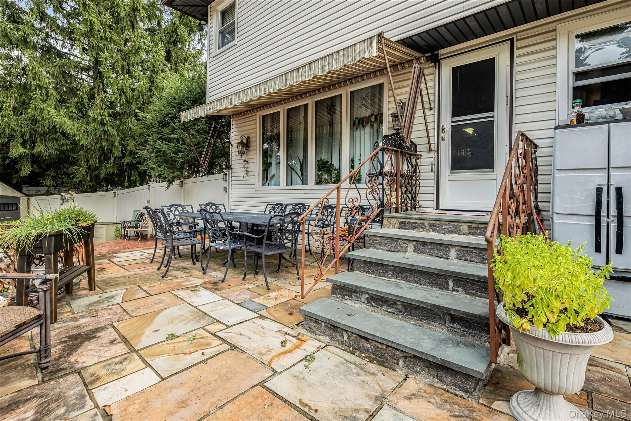 Expansive stone patio with natural stone steps and wrought iron railings Expansive stone patio with natural stone steps and wrought iron railings