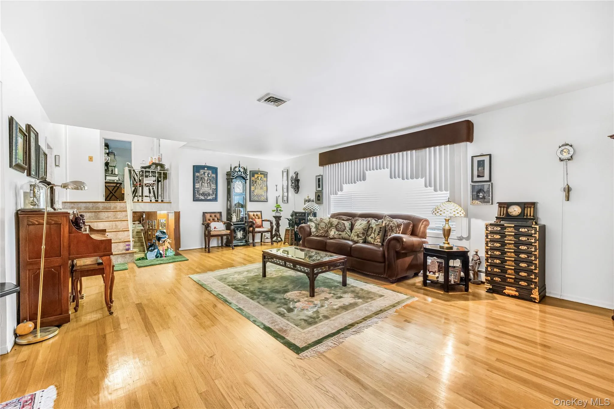 Light wood-finish flooring, white walls, and a multi-level floor plan with visible stairs Light wood-finish flooring, white walls, and a multi-level floor plan with visible stairs