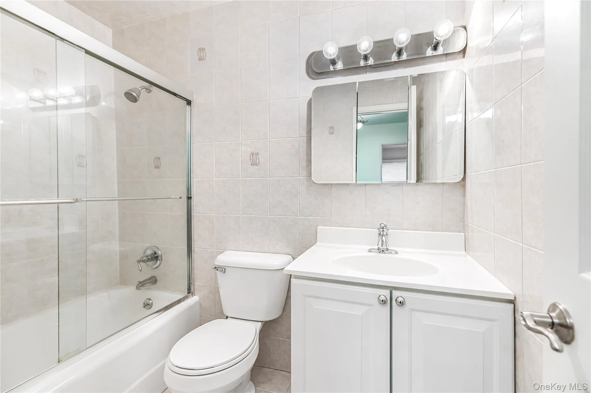 Bathroom featuring a white vanity with integrated sink, chrome faucet, and a medicine cabinet with a vanity light fixture Bathroom featuring a white vanity with integrated sink, chrome faucet, and a medicine cabinet with a vanity light fixture