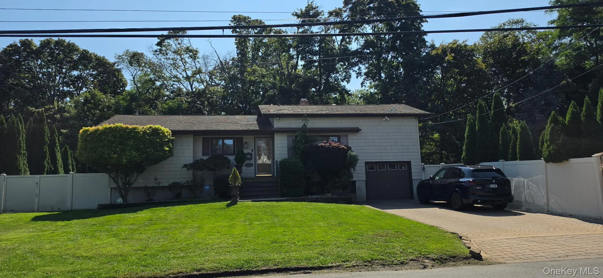 Single-story residence featuring light-colored siding and a dark roof Single-story residence featuring light-colored siding and a dark roof