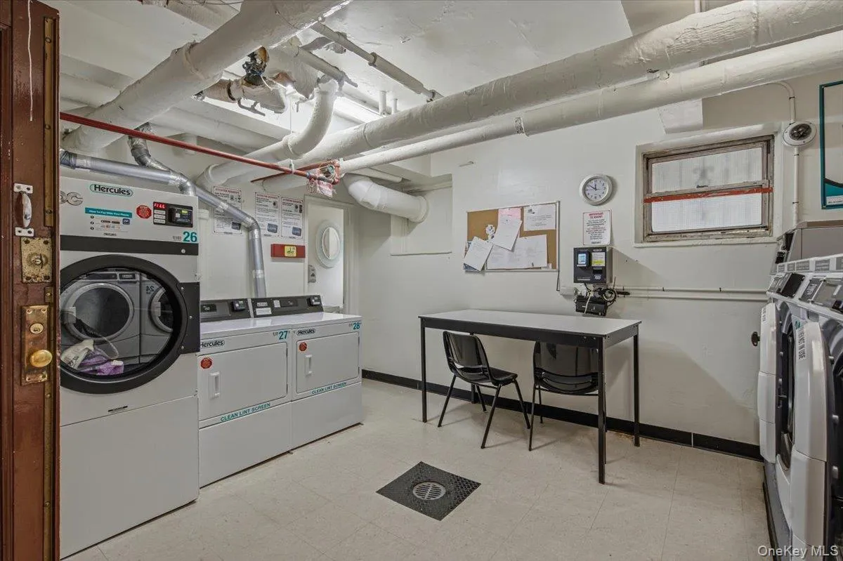 Laundry facility featuring multiple washer and dryer units, a utility sink, and a work surface Laundry facility featuring multiple washer and dryer units, a utility sink, and a work surface