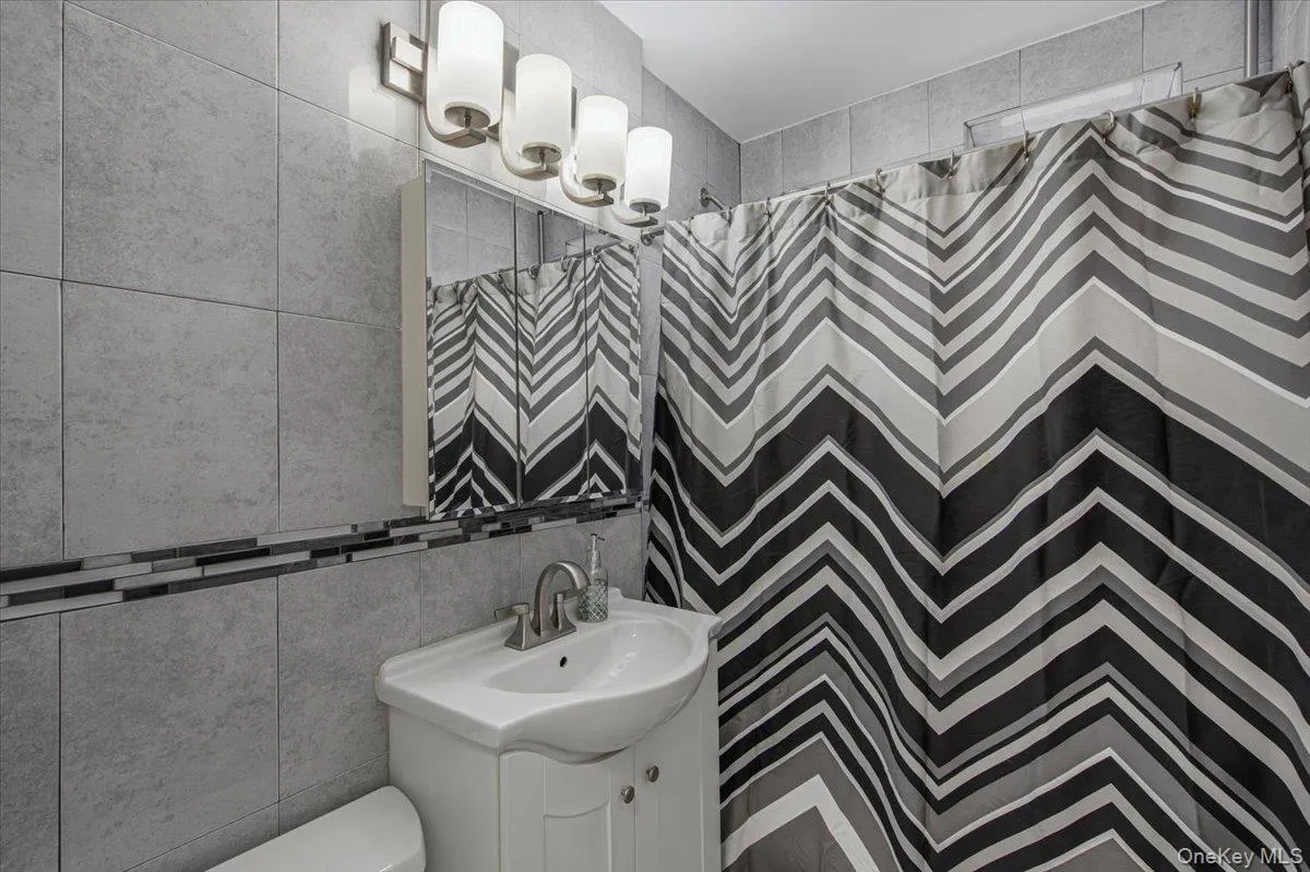 Light gray wall tiling with a dark mosaic accent Light gray wall tiling with a dark mosaic accent
