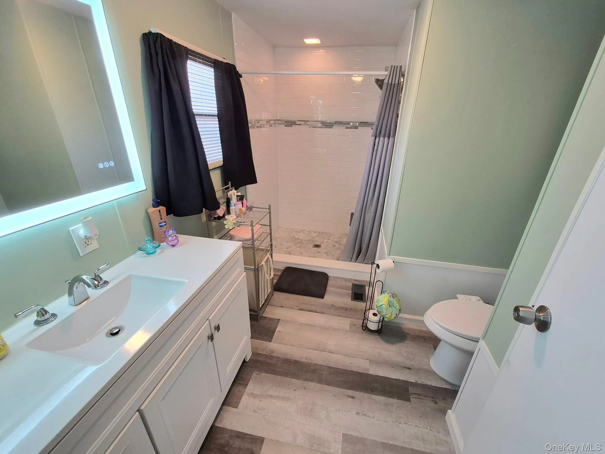 White vanity with integrated sink, chrome faucet, and backlit mirror White vanity with integrated sink, chrome faucet, and backlit mirror