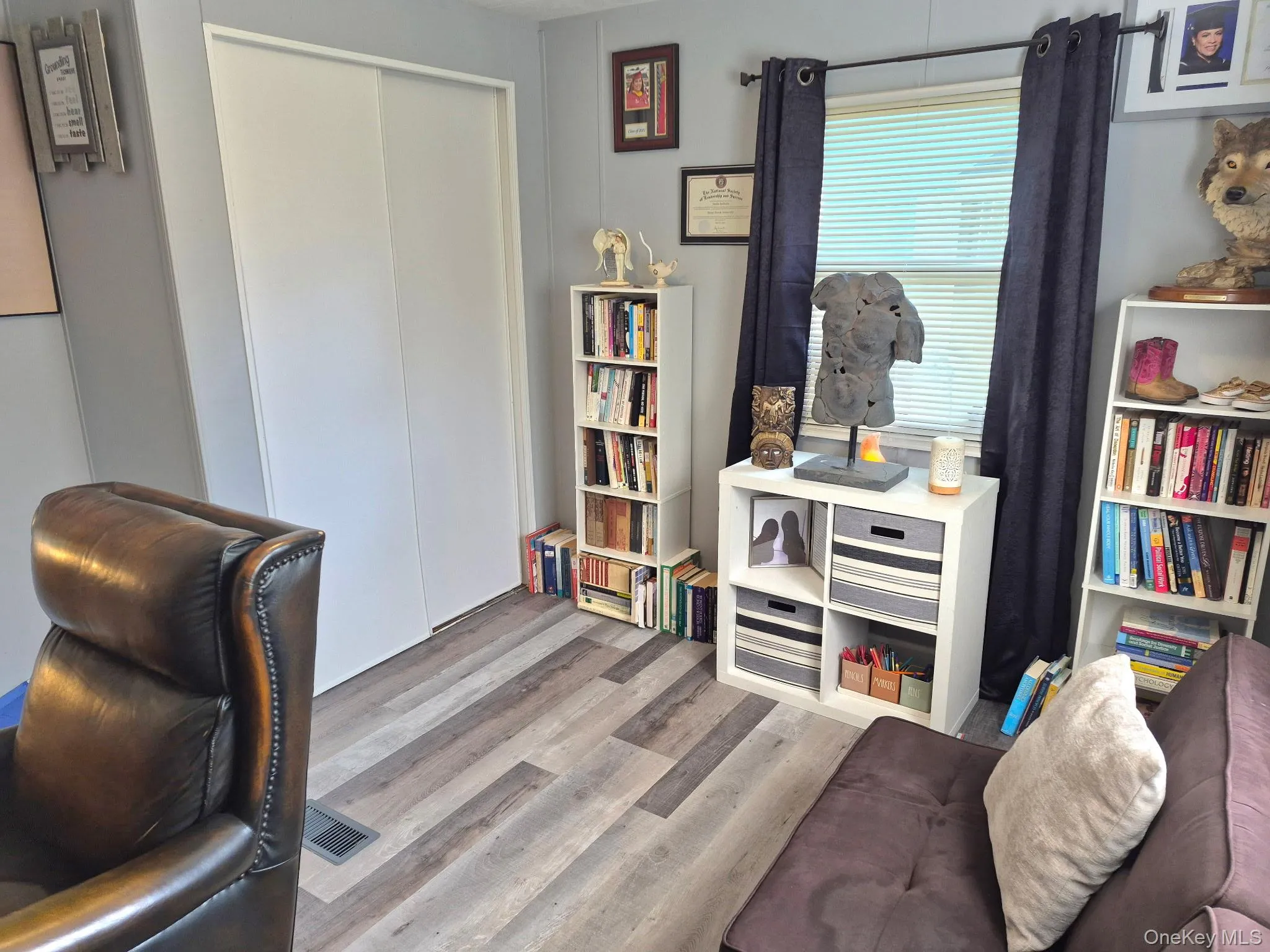 Sliding closet doors, wood-finish flooring, and a large window with blinds Sliding closet doors, wood-finish flooring, and a large window with blinds