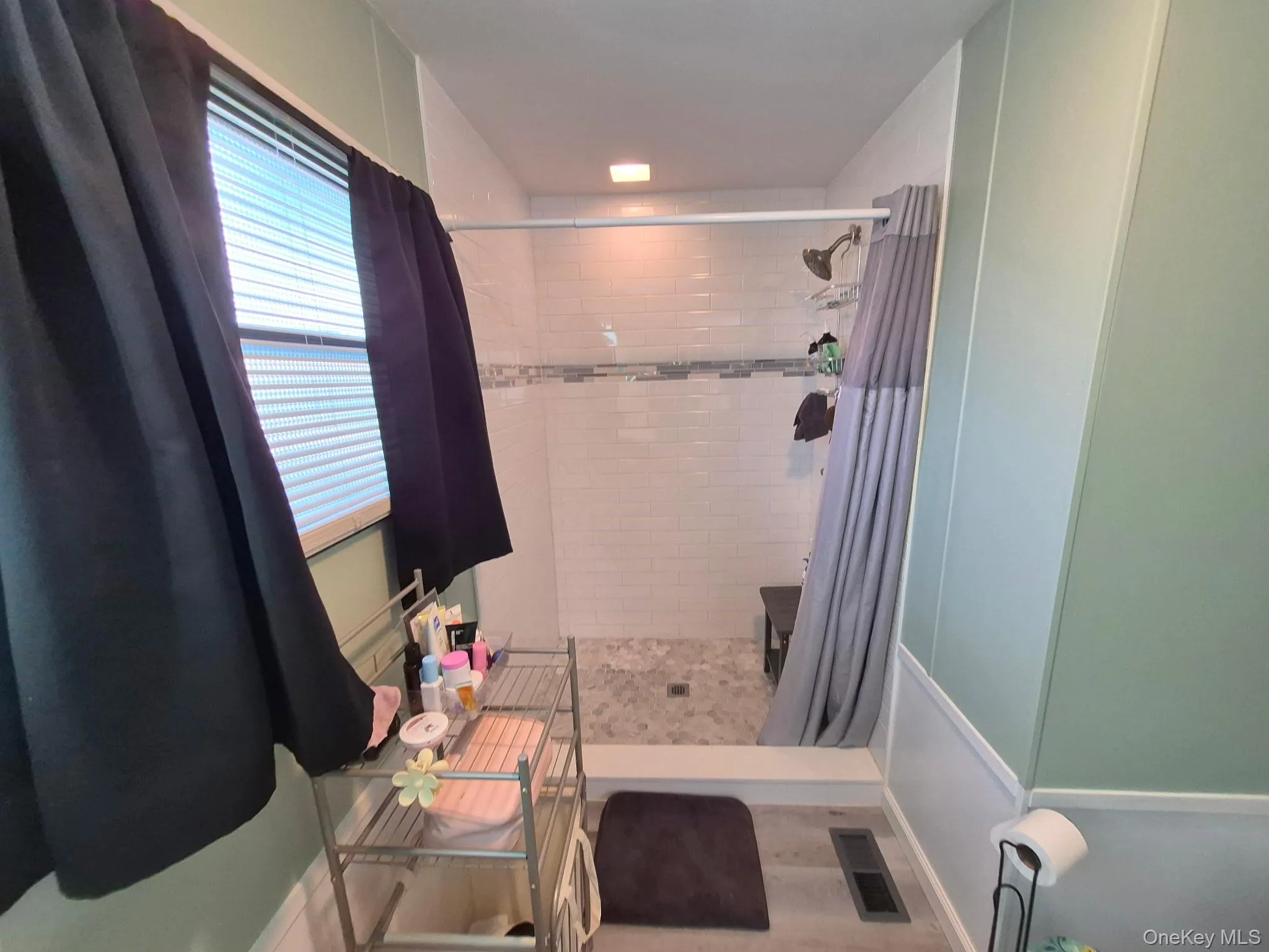 Shower with subway tile surround, decorative mosaic tile accent, and a built-in bench Shower with subway tile surround, decorative mosaic tile accent, and a built-in bench