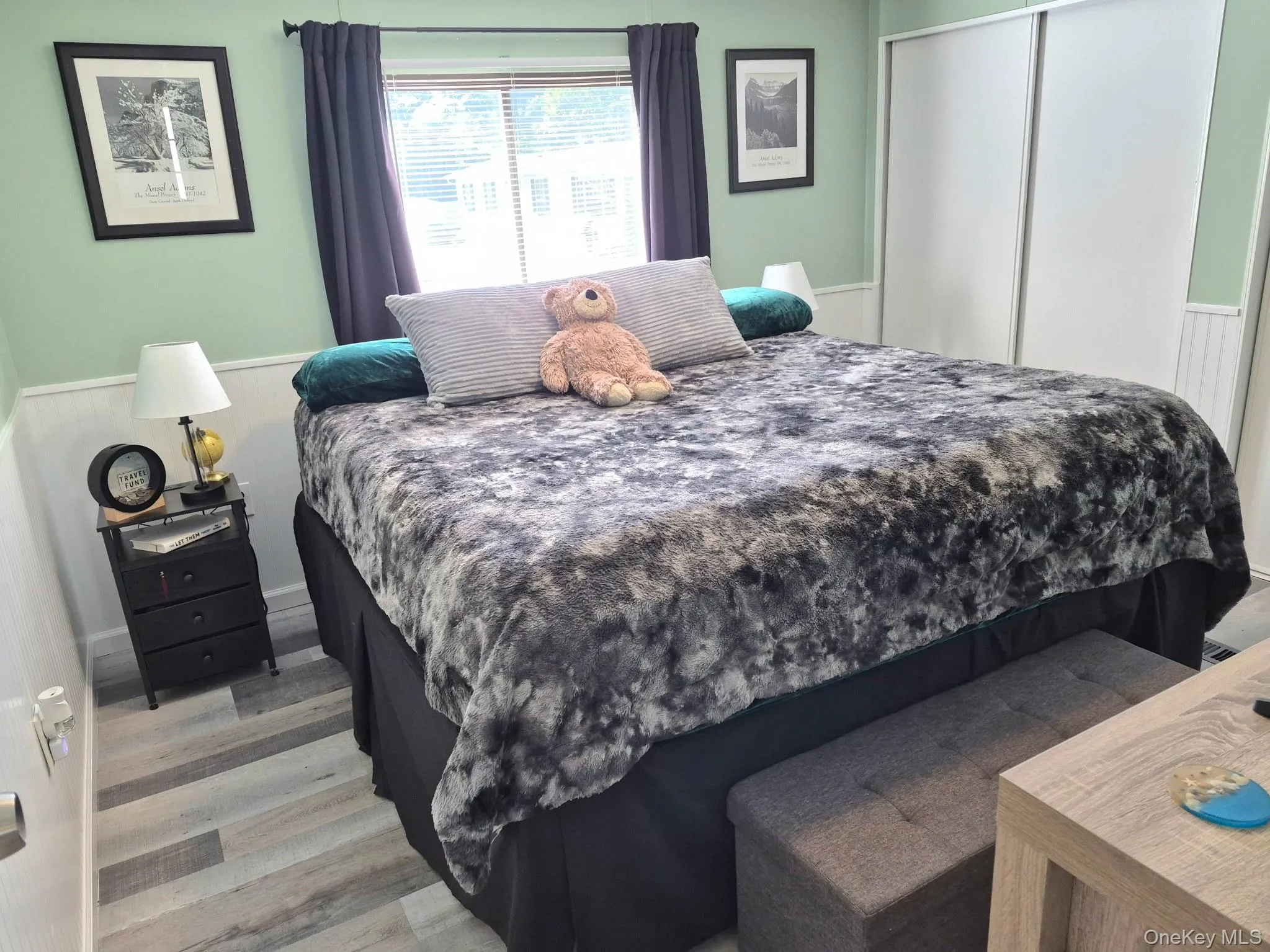Panel accent wall with light green paint and wood-finish flooring Panel accent wall with light green paint and wood-finish flooring