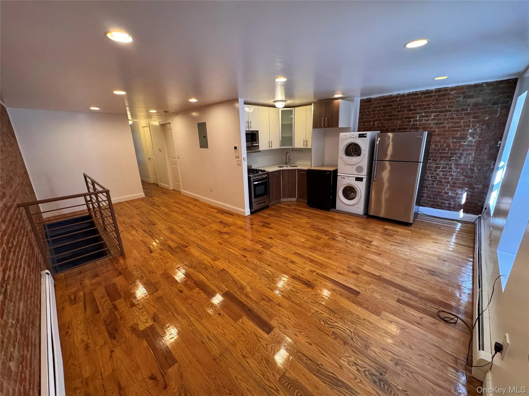 Hardwood flooring, exposed brick accents, recessed lighting, modern kitchen cabinetry, and stainless steel appliances Hardwood flooring, exposed brick accents, recessed lighting, modern kitchen cabinetry, and stainless steel appliances