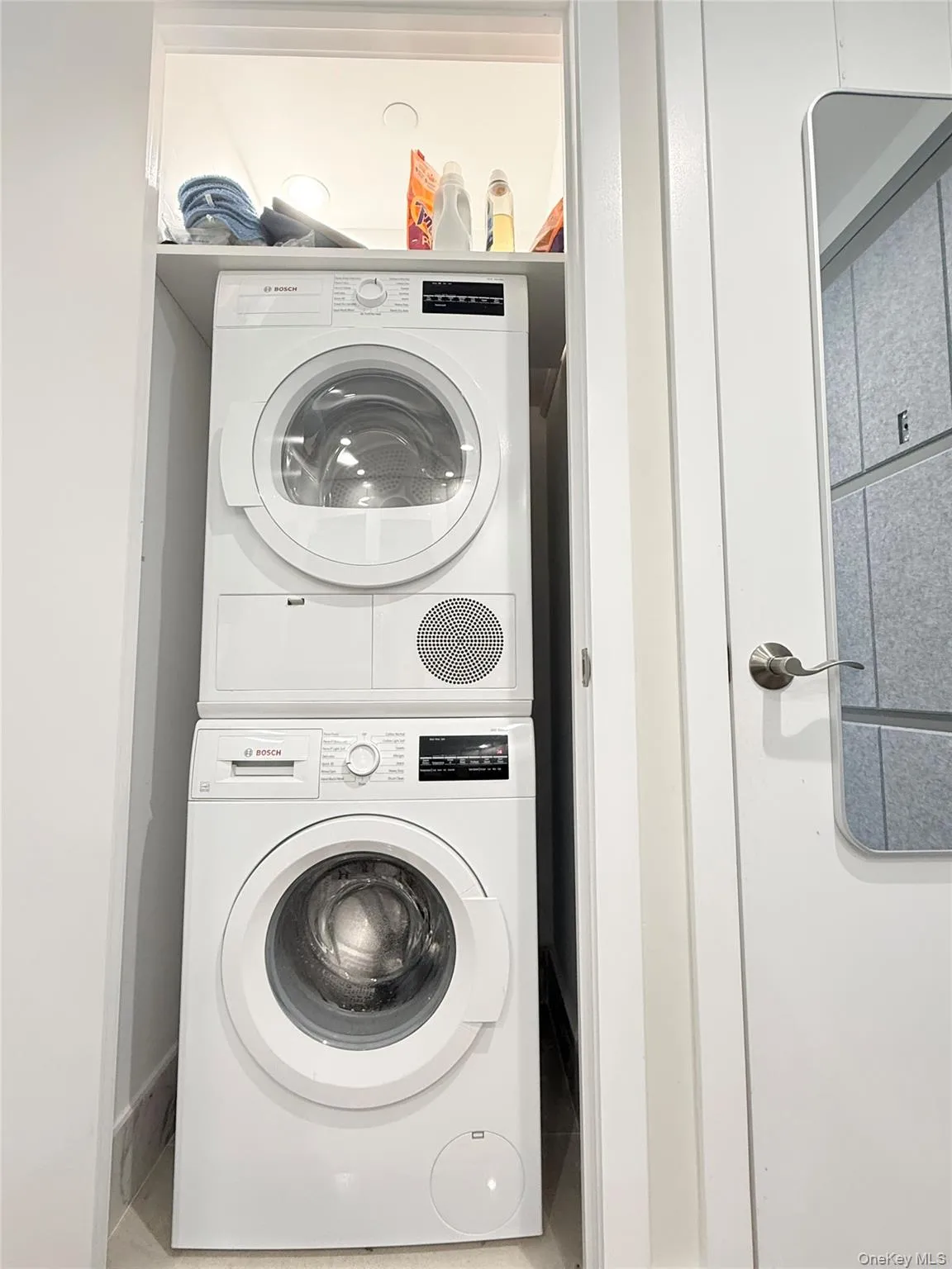 Stacked washer and dryer unit with a built-in overhead shelf Stacked washer and dryer unit with a built-in overhead shelf