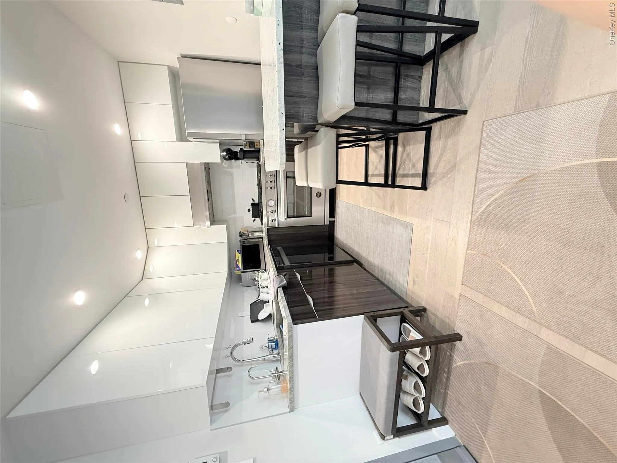 Modern kitchen featuring white upper cabinetry, dark wood-finish lower cabinetry, and stainless steel appliances Modern kitchen featuring white upper cabinetry, dark wood-finish lower cabinetry, and stainless steel appliances